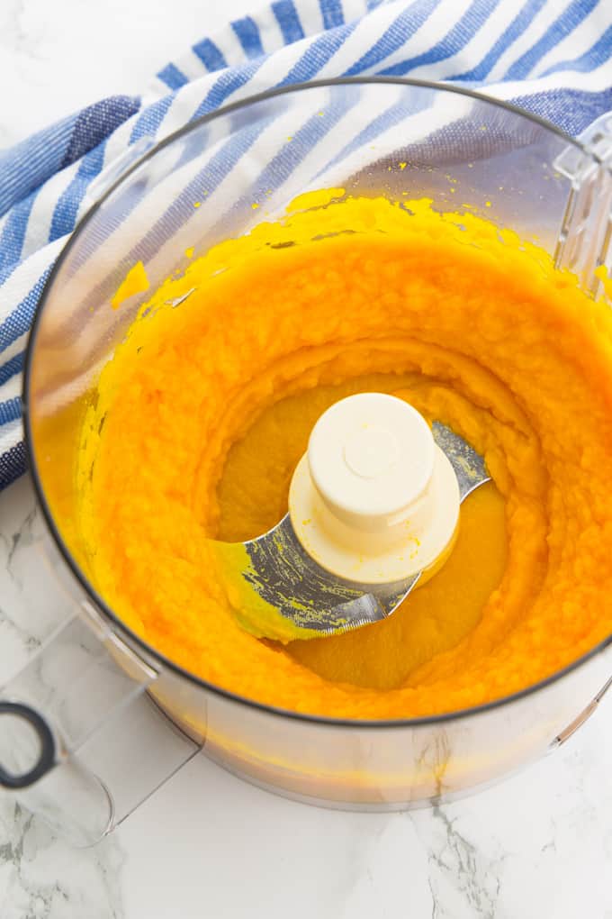 pumpkin puree in a food processor on a marble counter top