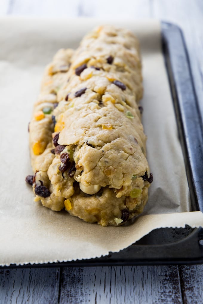 a German stollen on a black baking sheet lined with parchment paper before baking 