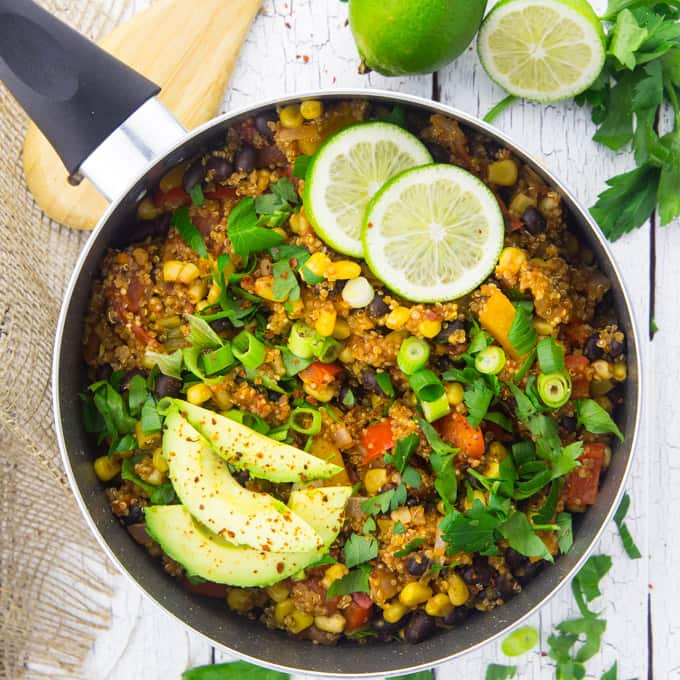 Mexican Quinoa in a black pot with avocado and lime slices on top