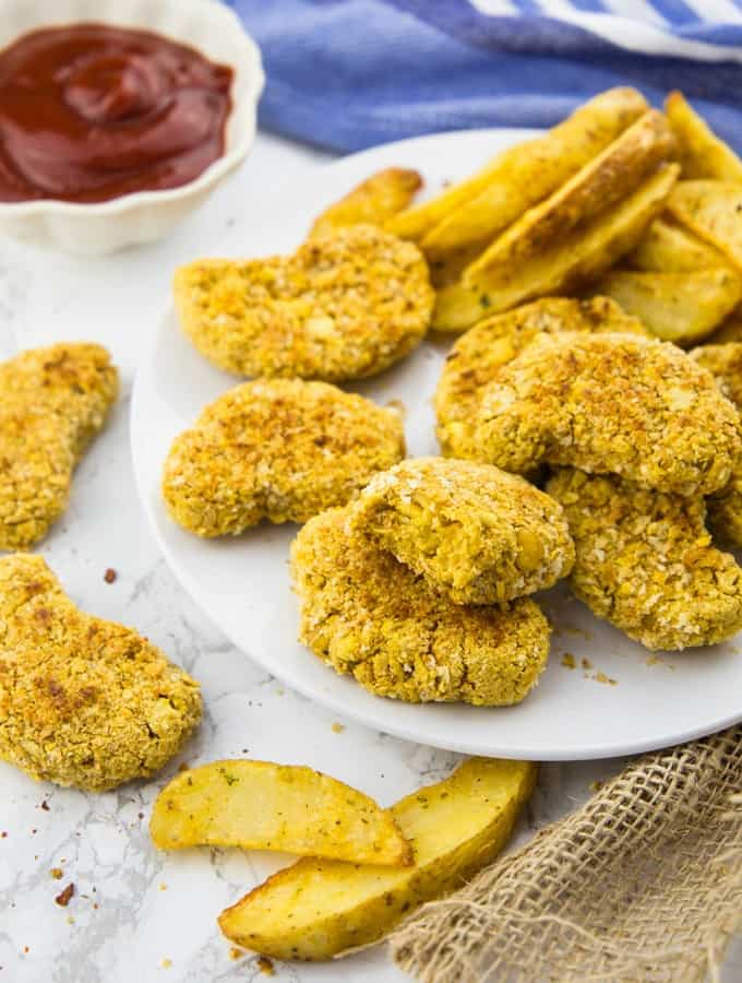 Vegan Chicken Nuggets on a White Plate with a Small Bowl of Ketchup in the Background