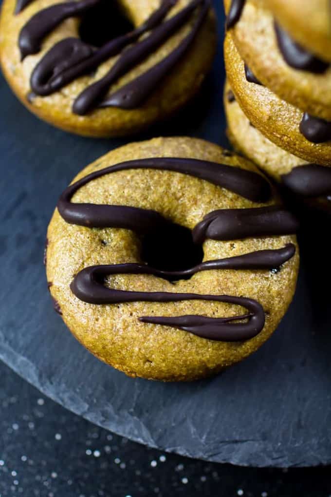 six vegan donuts with chocolate glaze on a slab of slate 