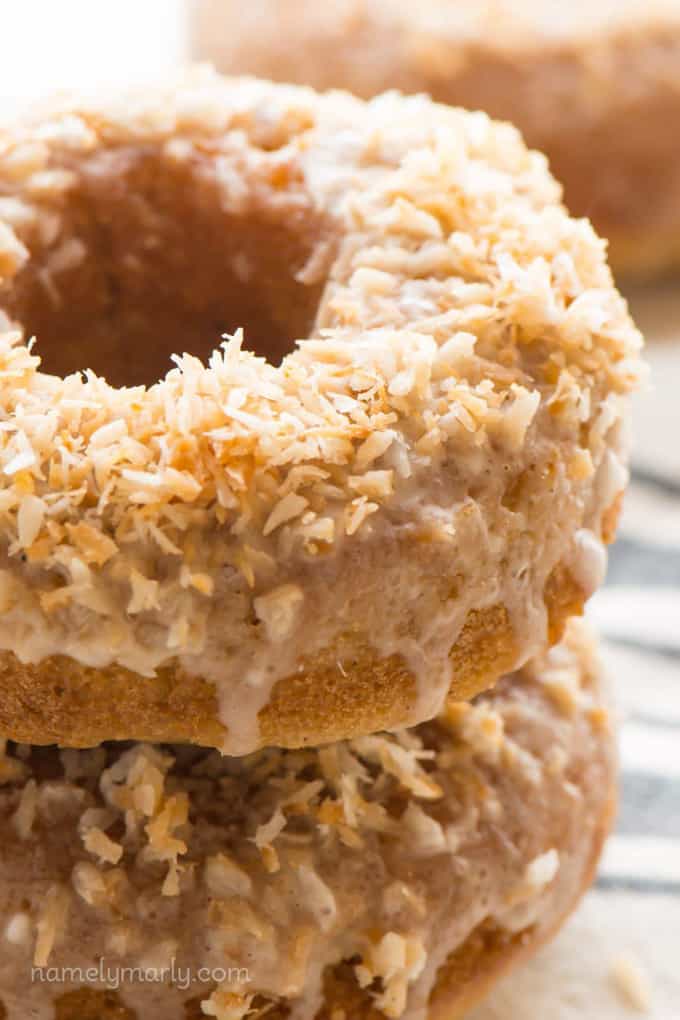 a close up photo of a stack of two vegan coconut donuts 