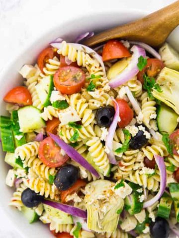 Greek Pasta Salad in a Bowl with a Salad Server