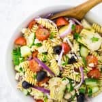 Greek pasta salad with cherry tomatoes, cucumber, olives, red onion, and artichokes