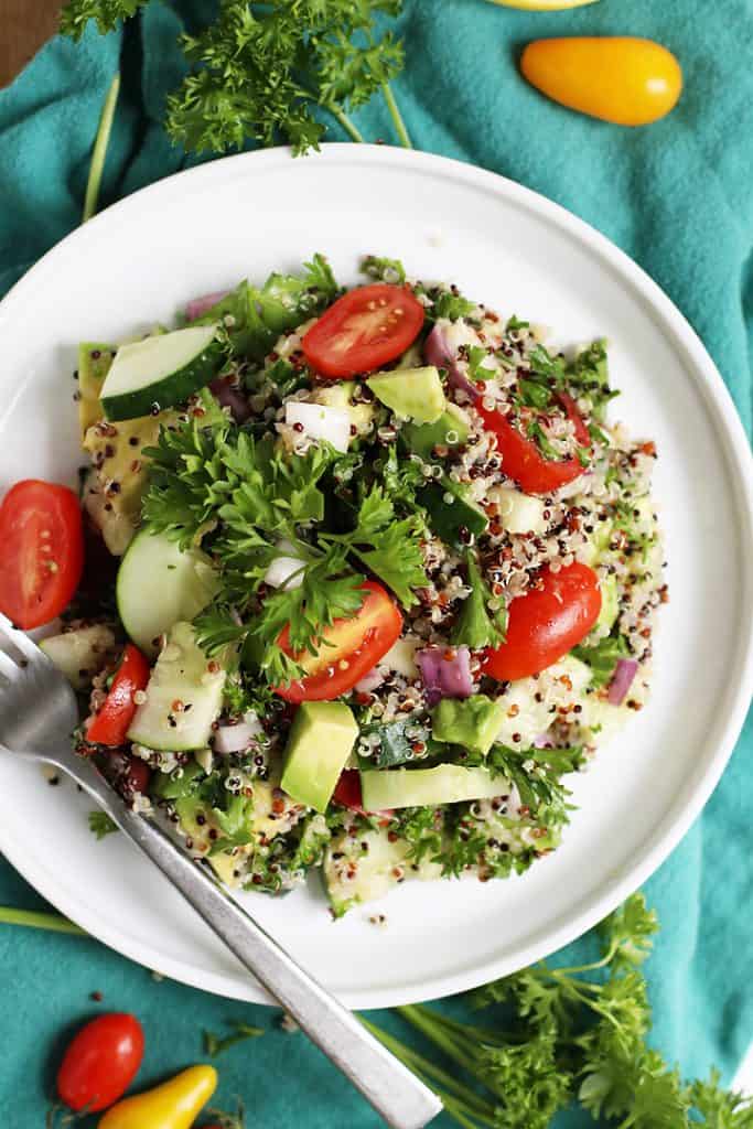 Mediterranean Quinoa Salad on a white plate with a fork on the side