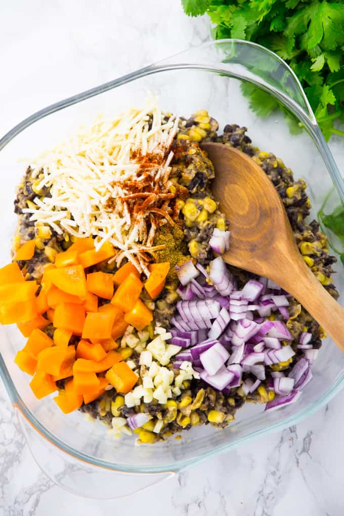 corn, black beans, cheese, chopped bell pepper, red onions, and garlic in a mixing bowl
