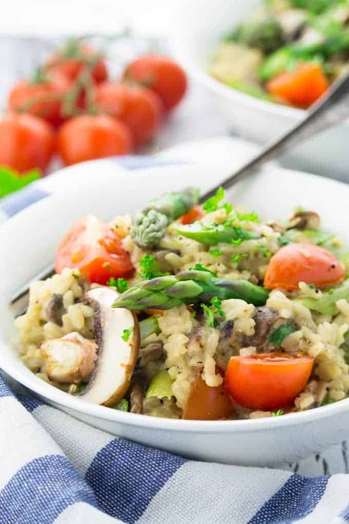 vegan risotto with cherry tomatoes and fresh parsley on top 
