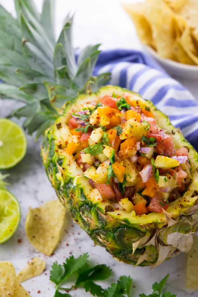 Pineapple Salsa in a Pineapple with Tortilla Chips and Limes on the Side
