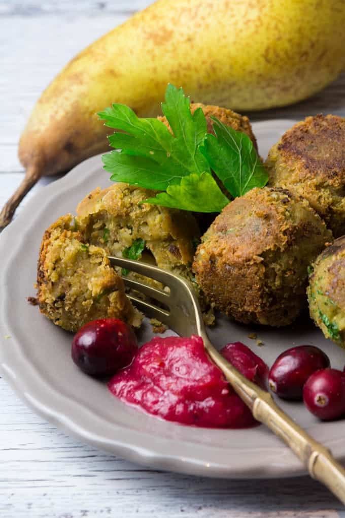 festive vegan falafel with cranberry pear sauce on a grey plate with a pear in the background 