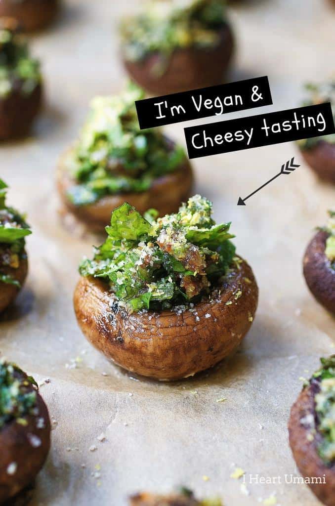 Herb Stuffed Mushrooms on parchment paper with the writing "I'm vegan & cheesy tasting" 