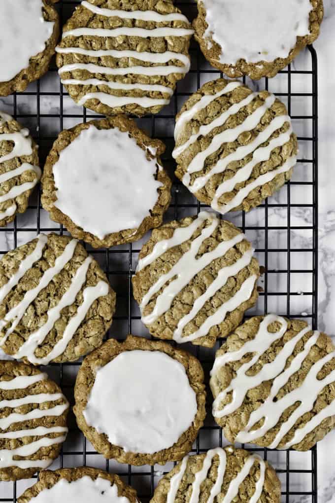 vegan oatmeal cookies with icing on a cooling rack 