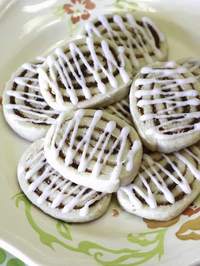 Gluten-Free Cinnamon Roll Sugar Cookies on a white plate with flowers 