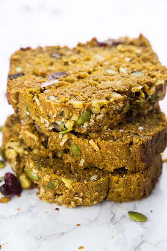 a stack of three slices of vegan pumpkin bread on a marble counter top