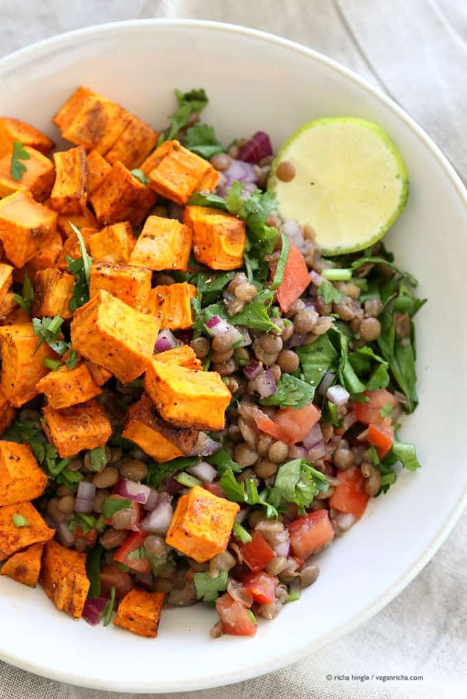 . Curried Sweet Potato Lentil Salad in a white bowl with a slice of lime on the side 