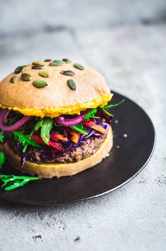 a black bean rice burger on a black plate on a concrete counter top 