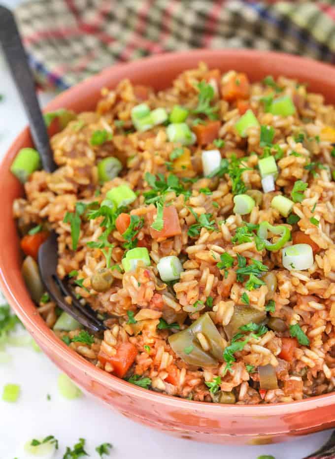 Teriyaki Instant Pot Rice in an orange bowl with a spoon on a white counter top 