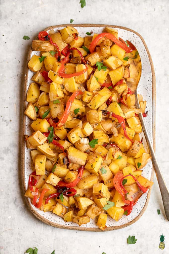 oven roasted breakfast potatoes on a white plate with a spoon 