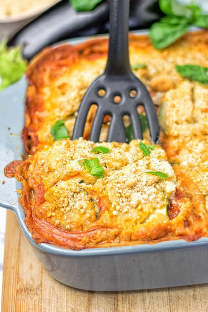 Eggplant Parmesan Zucchini Casserole in a grey casserole dish on a wooden counter top 