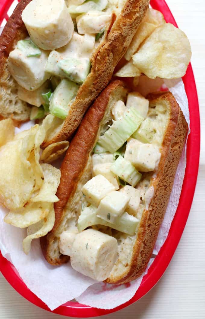 Two Easy Vegan Maine Lobster Rolls on a white and red plate with chips on the side