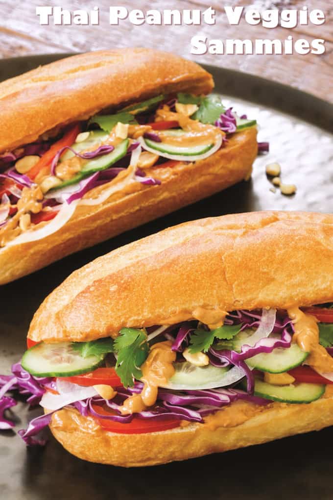 Two Thai Peanut Veggie Sandwiches on a dark countertop with the writing "Thai peanut veggie sammies" on top of the photo