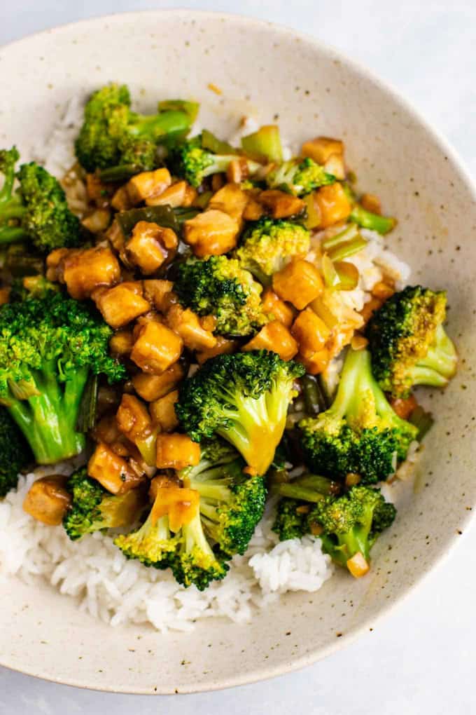 Broccoli Tofu Stir Fry served over basmati rice in a white bowl on a white countertop