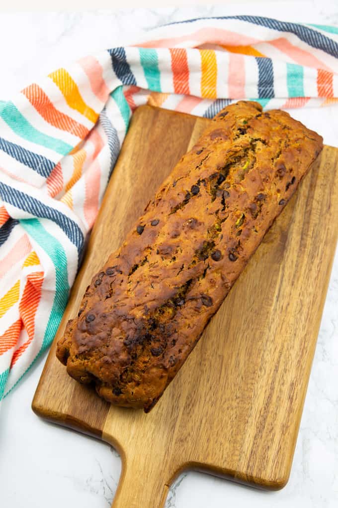 a freshly baked zucchini bread on a wooden cutting board 