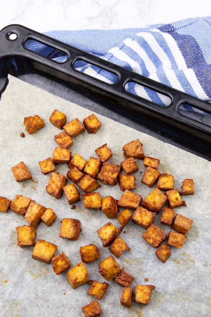 baked tofu cubes on a baking sheet lined with parchment paper 