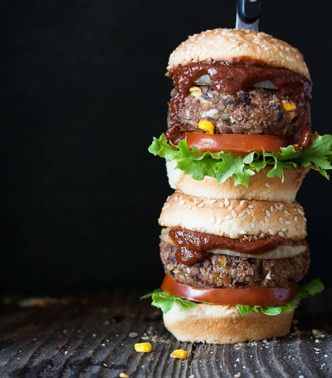 a stack of two vegan black bean burgers with a black background 