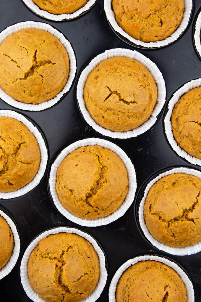 a close-up photo of pumpkin muffins in a black muffin pan