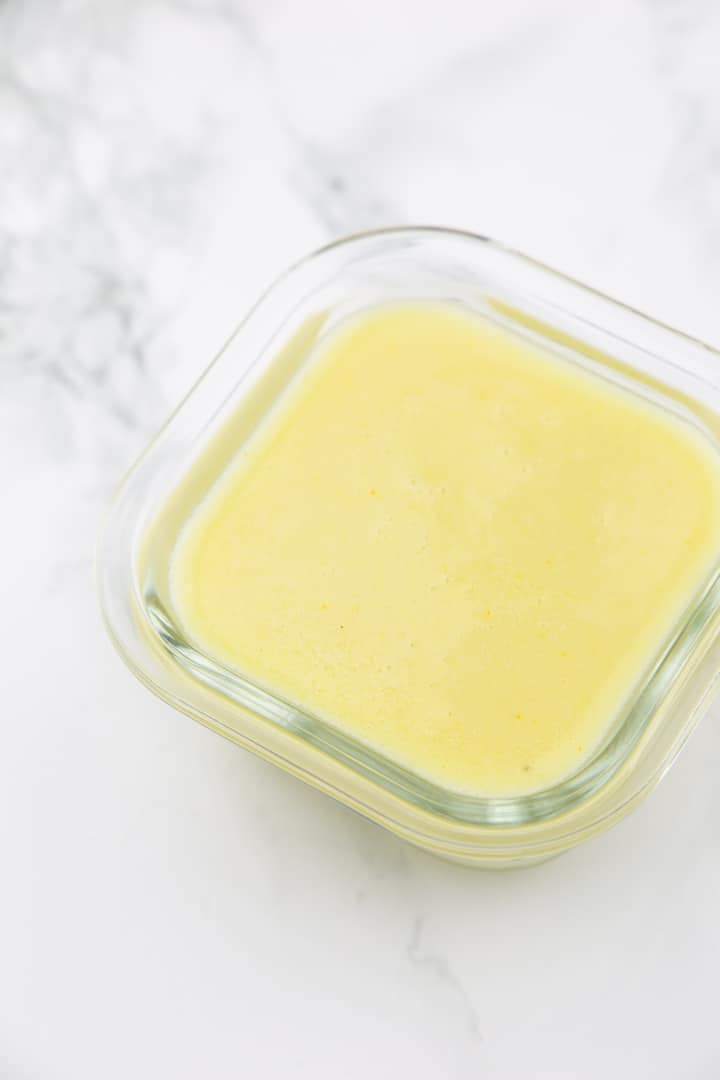 Vegan butter in a small glass bowl on a marble counter 