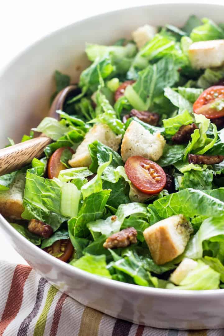 Vegan BLT Salad in a white bowl on a striped dishcloth 