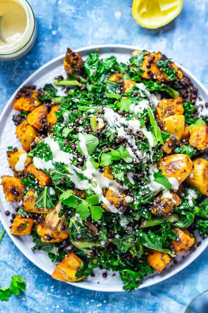 sweet potato quinoa salad on a white plate on a blue countertop 