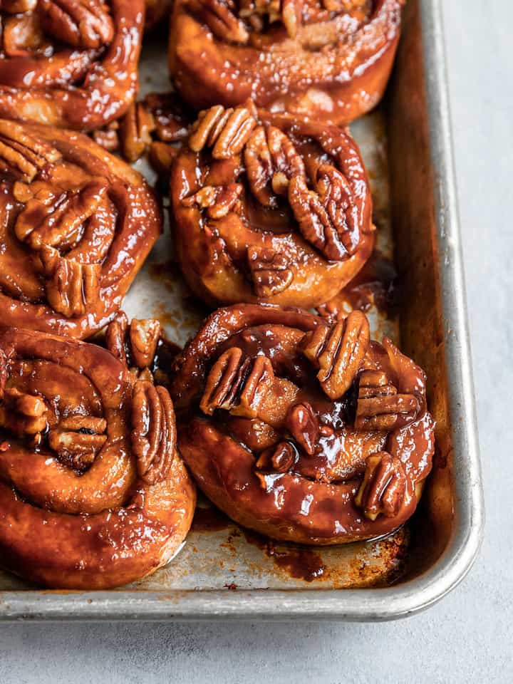 six vegan carrot cake sticky buns in a baking dish