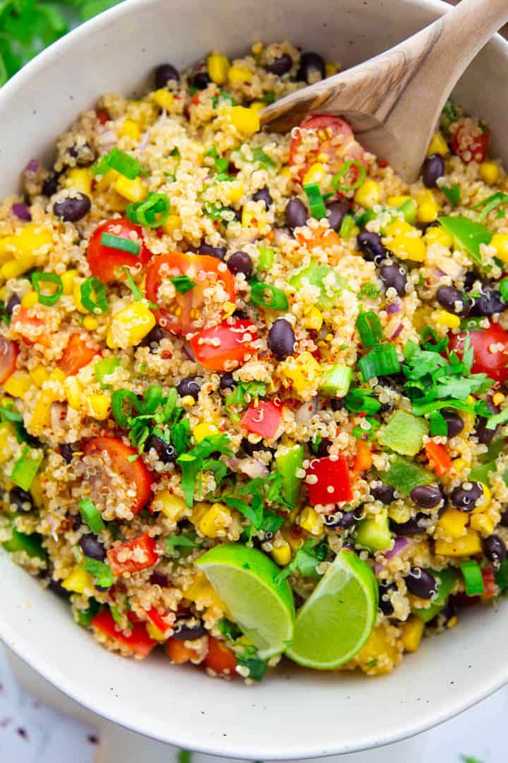 Quinoa Black Bean Salad in a white bowl with a wooden spoon