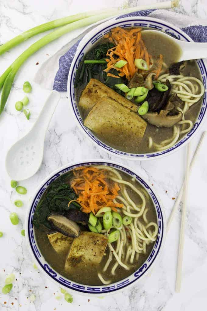 two bowls of vegan ramen with tofu on a marble countertop 