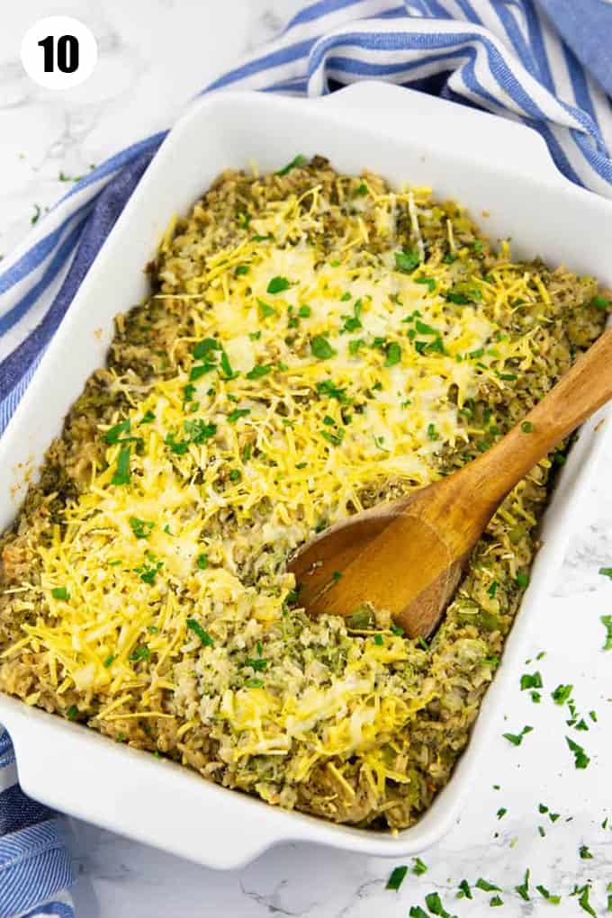 a white baking dish with broccoli rice casserole on a marble countertop 