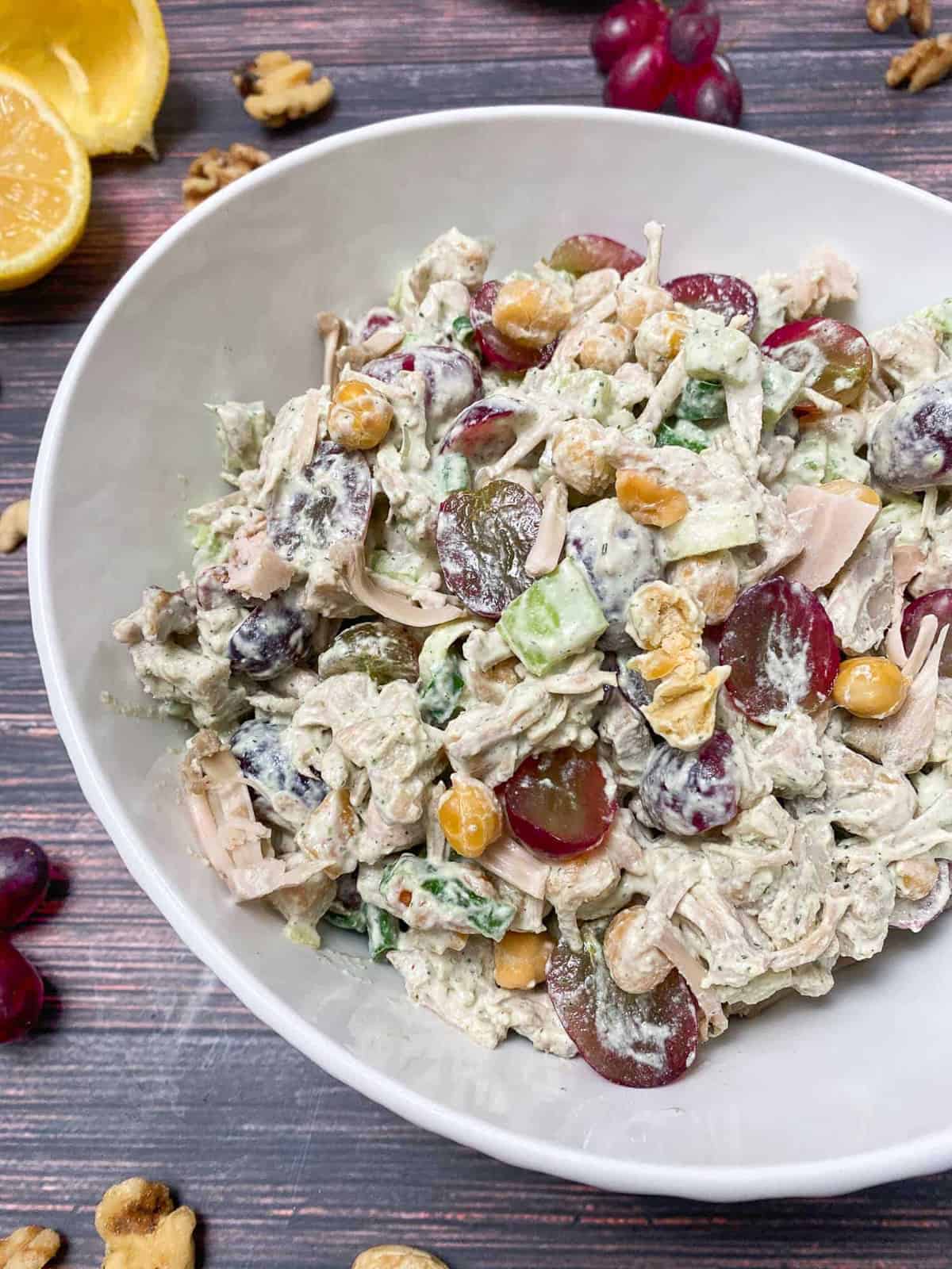 vegan chicken salad with grapes in a white bowl on a wooden countertop 