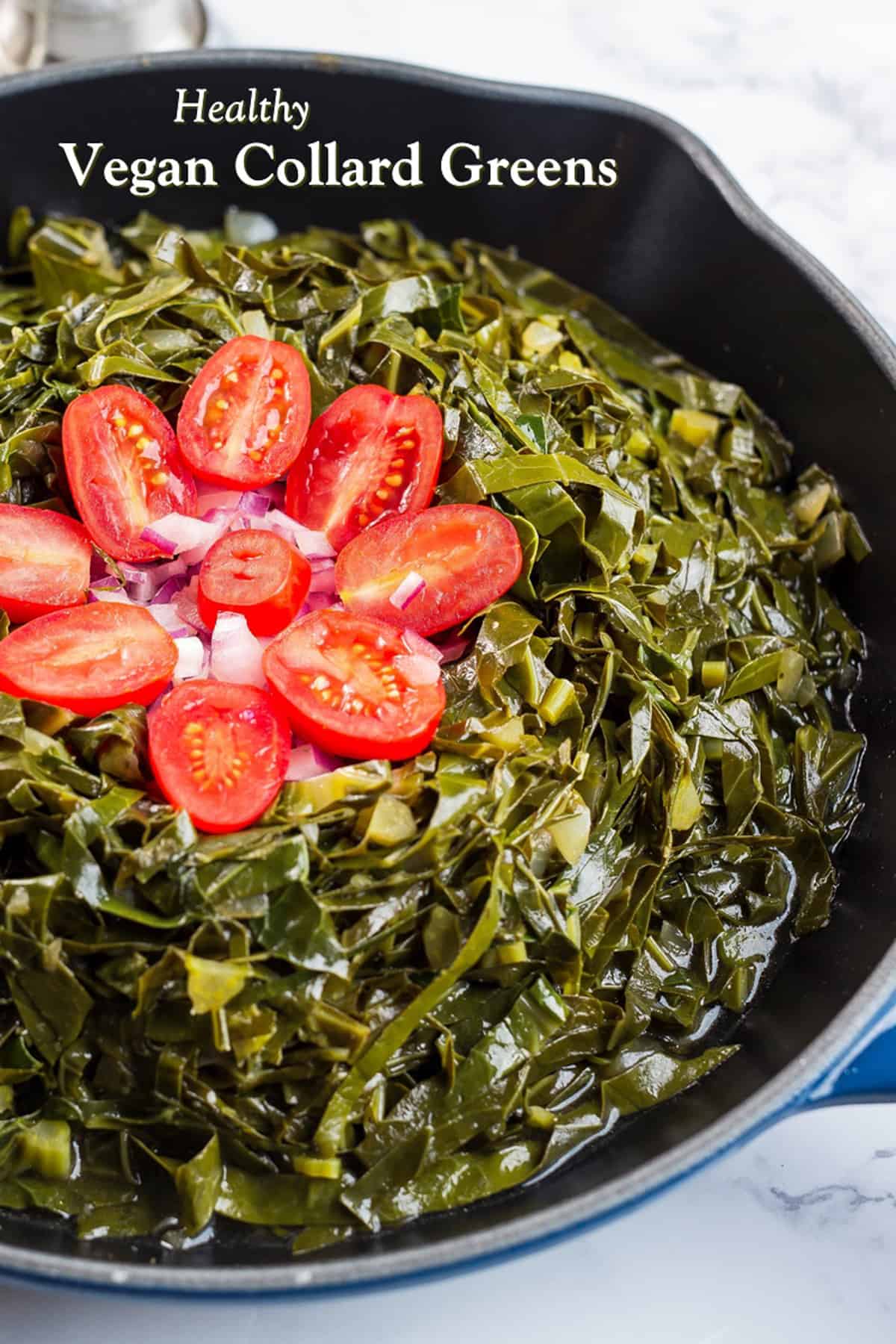 Vegan Collard Greens in a black pan with cherry tomatoes on top 