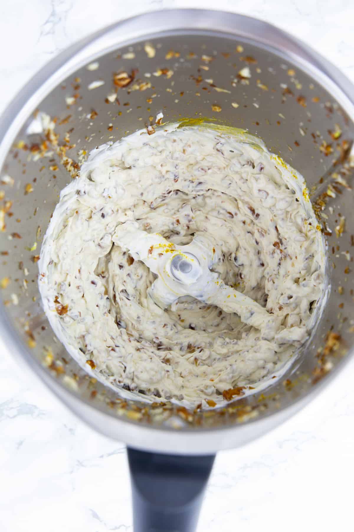 a vegan cream cheese dip in a blender on a marble countertop 