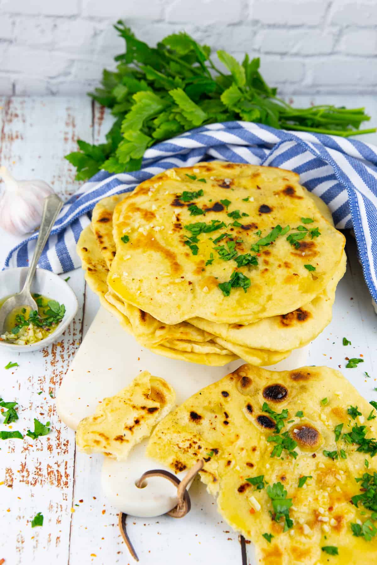 a stack of naan bread sprinkled with chopped parsley 