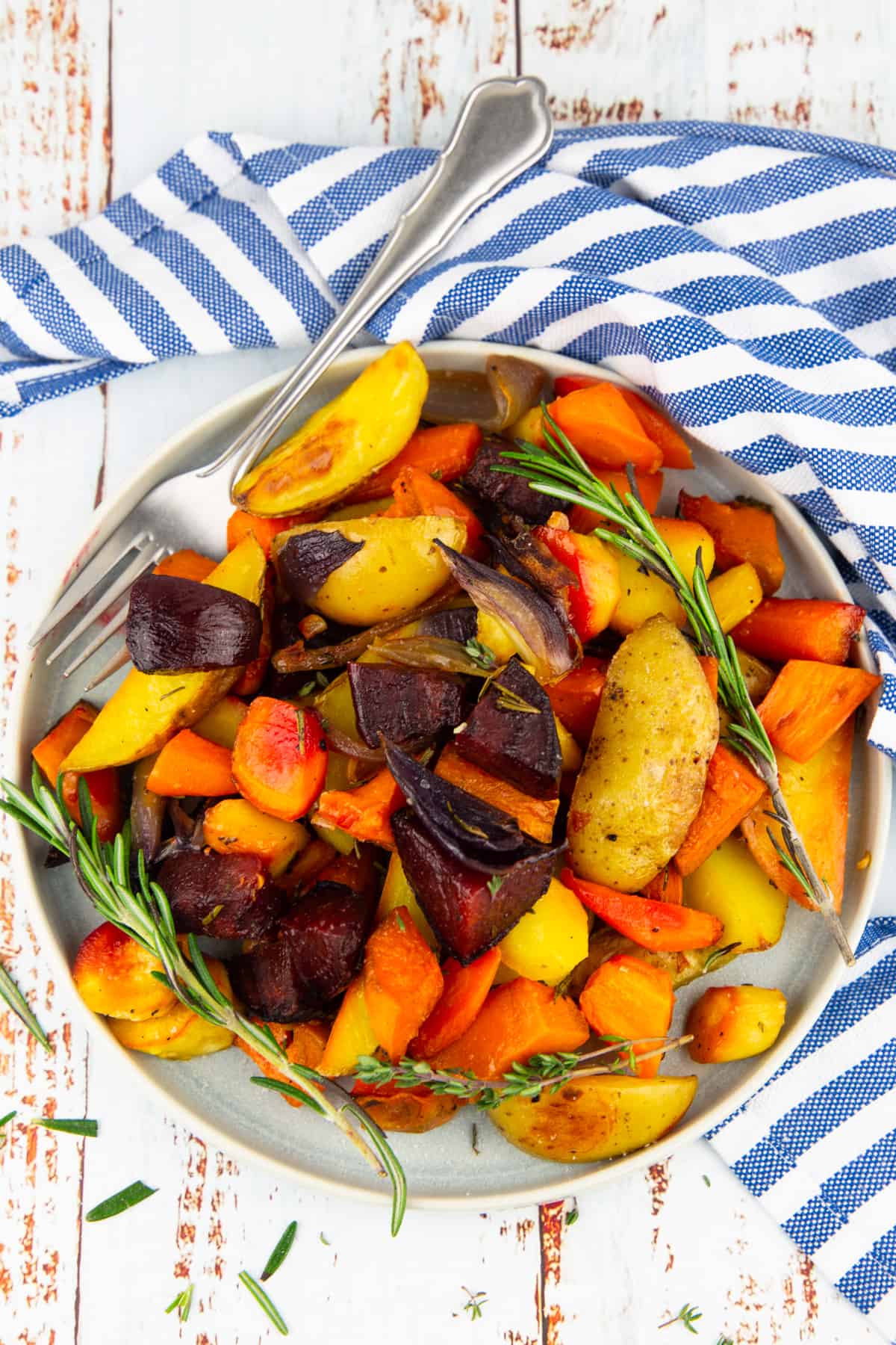 roasted veggies on a grey plate on a wooden board
