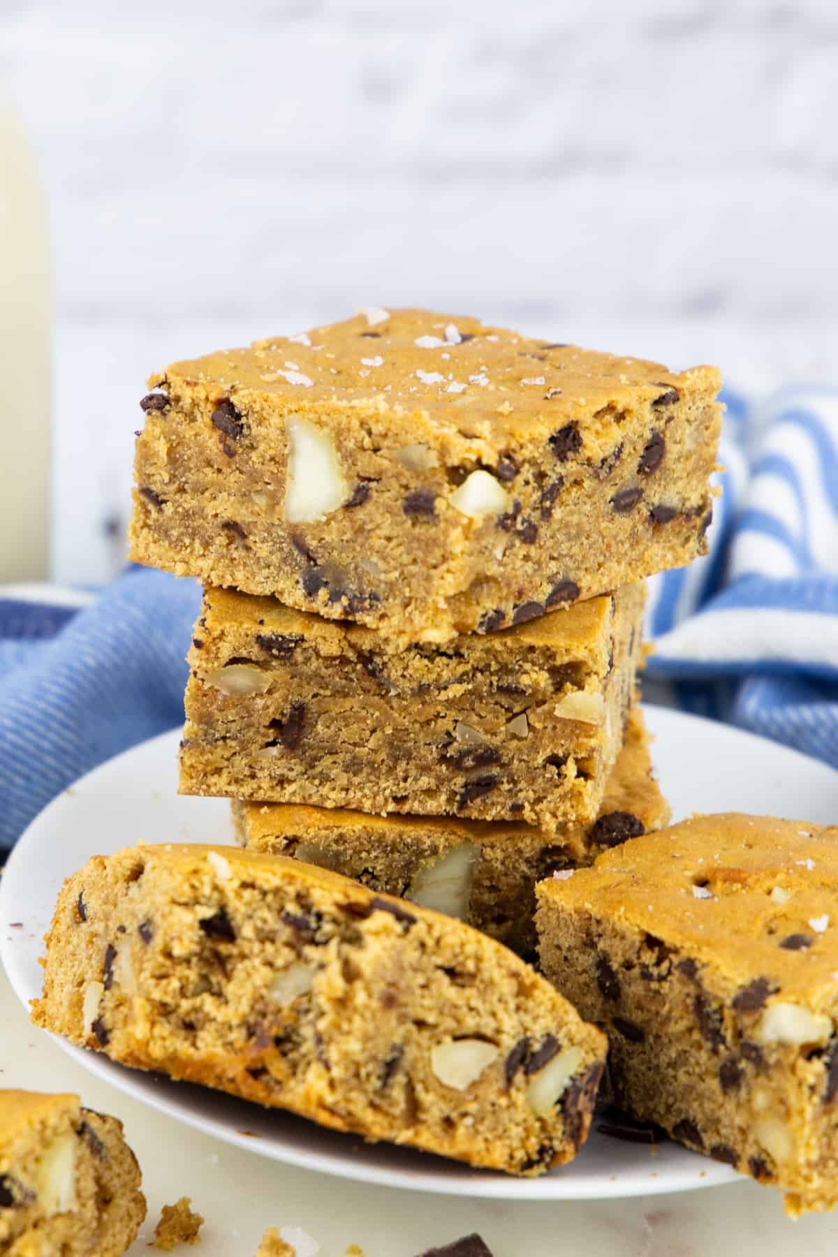 a stack of blondies with macadamia nuts on a white plate