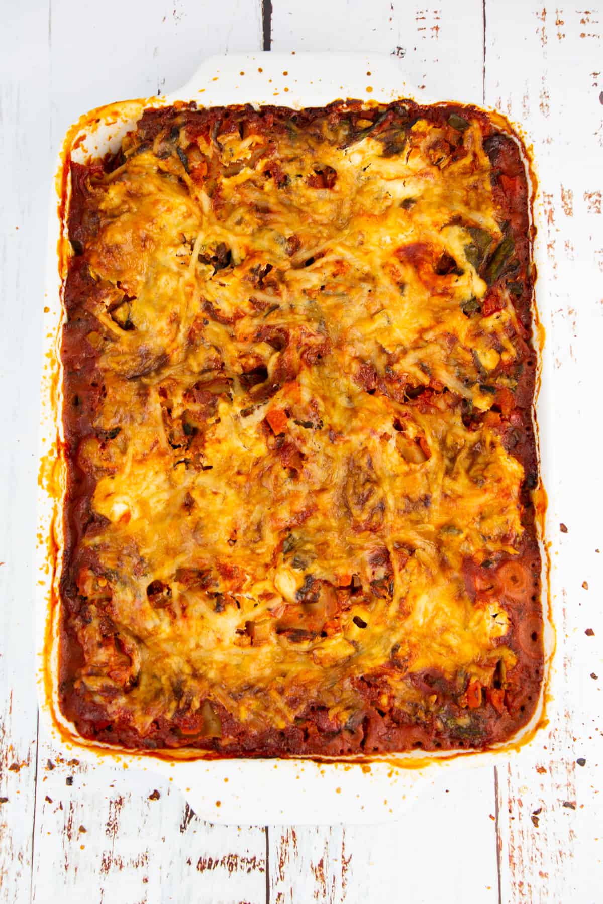 a vegetable lasagna fresh out of the oven on a wooden board