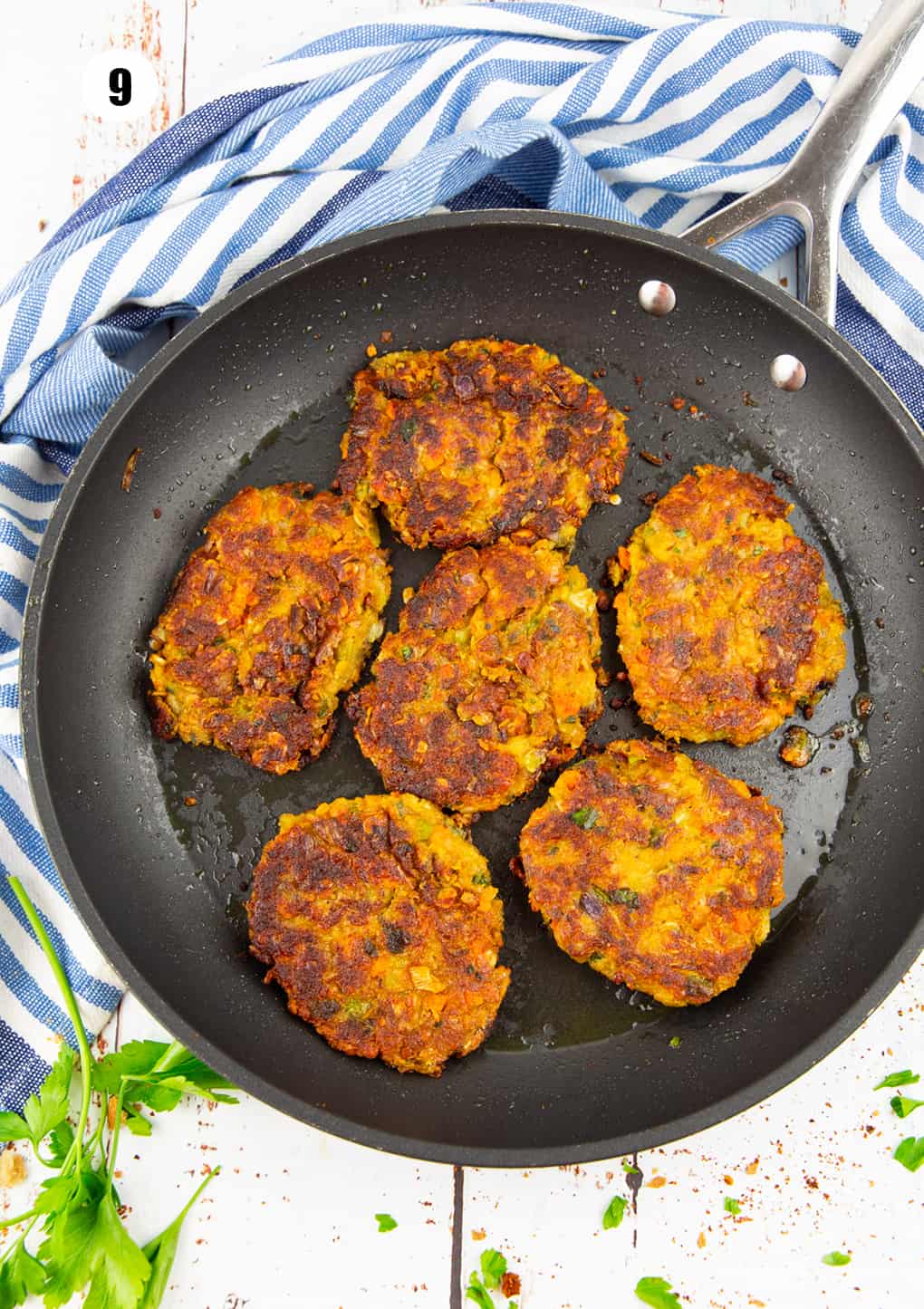 six lentil burgers in a black pan on a white wooden board 