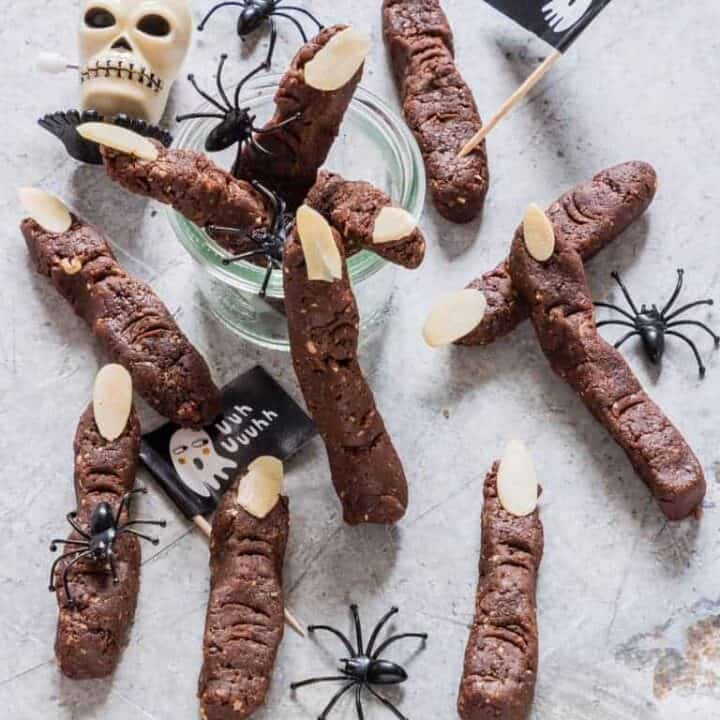 zombie fingers on a concrete countertop decorated with plastic spiders and a skull