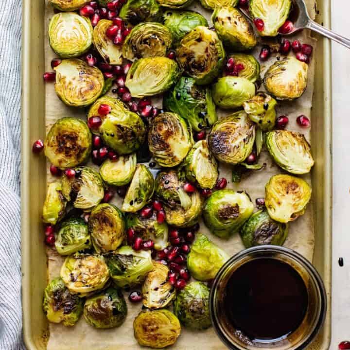 Roasted Brussels sprouts with pomegranate seeds on a baking tray