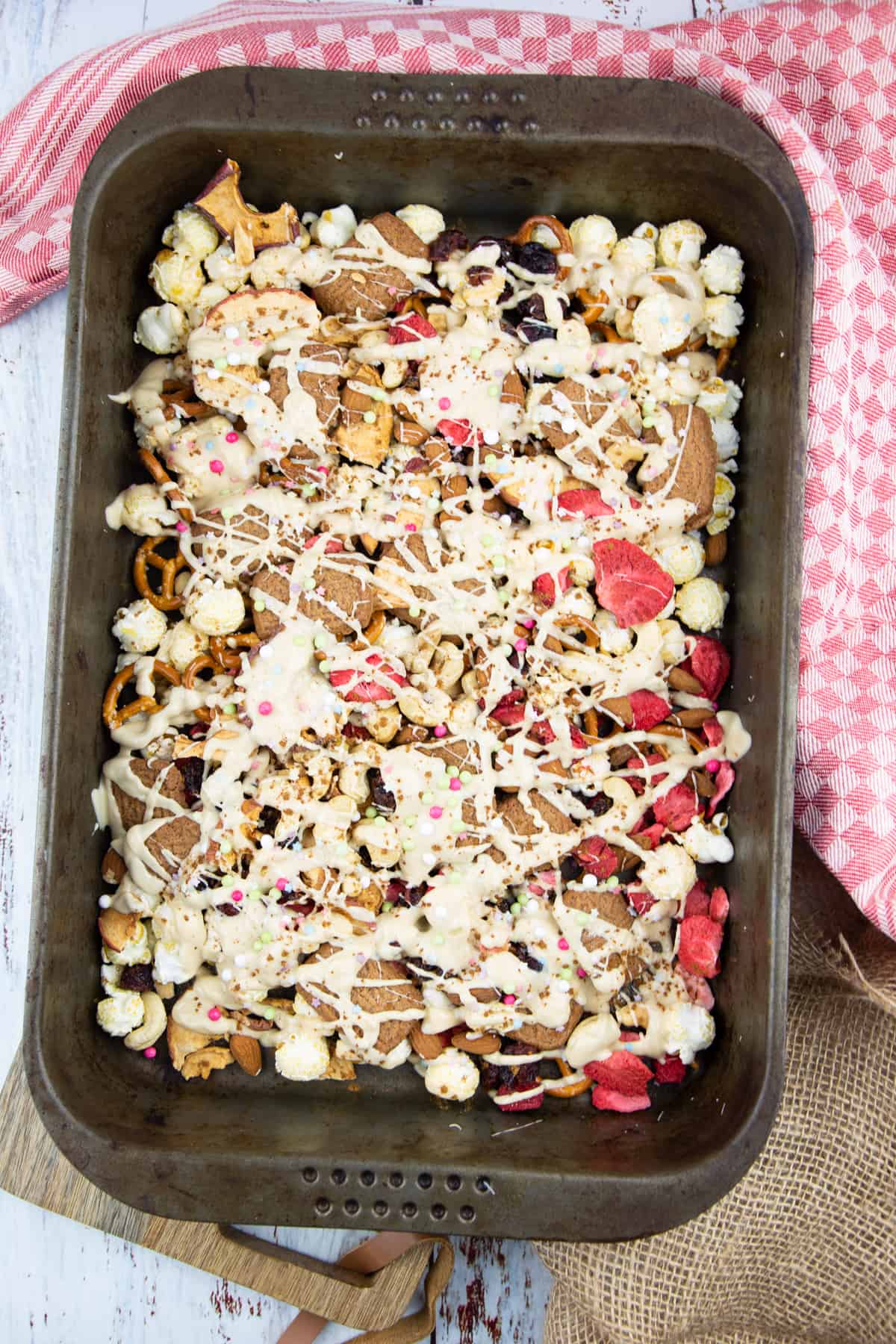 vegan candies and nuts on a sheet pan topped with vegan white chocolate 