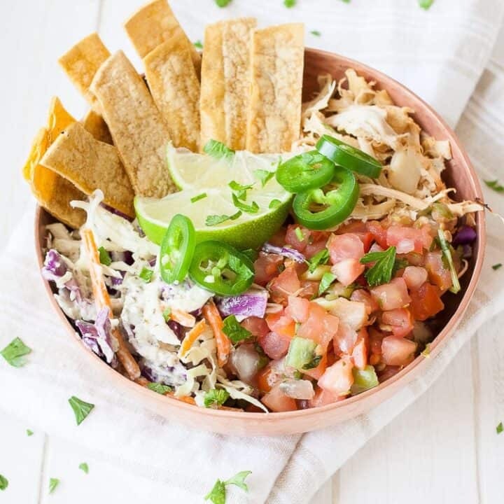 a vegan fish taco bowl on a white wooden board
