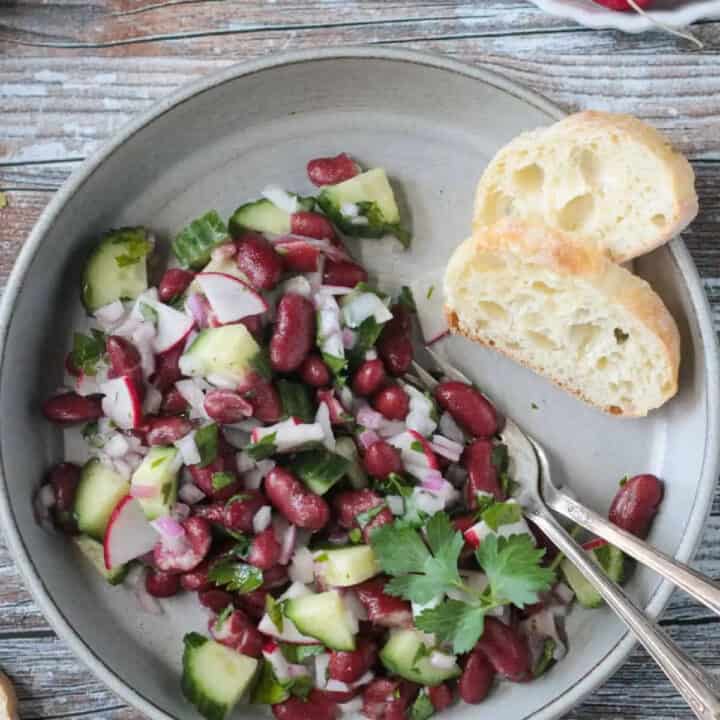 kidney bean salad with cucumber and radishes on a grey plate