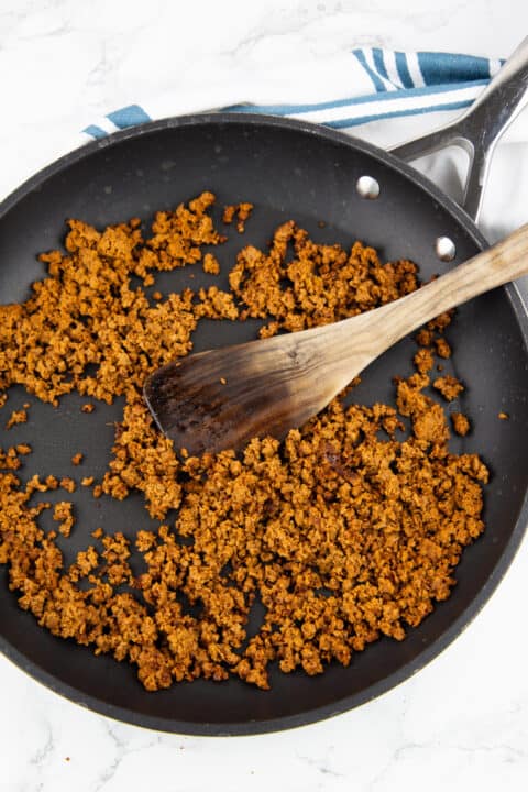 vegan ground meat in a black pan with a wooden spatula